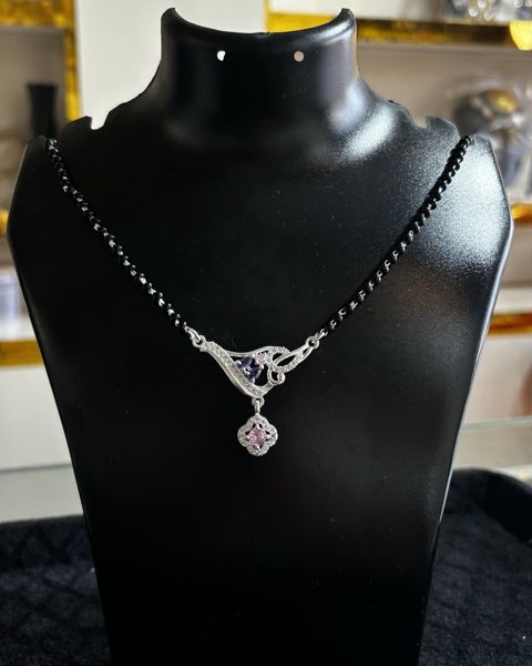 Mangalsutra with black beads and a pendant, on a display bust