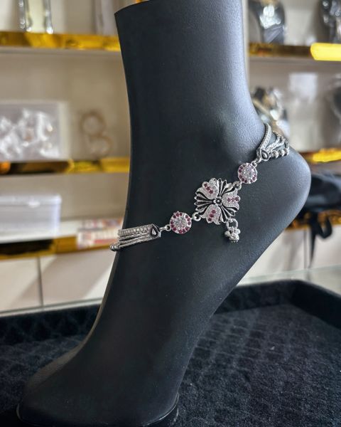 Silver payal with a floral centrepiece, on a display foot